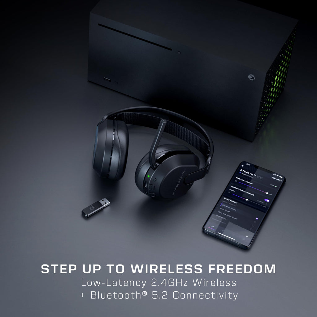 Gaming console, wireless headphones, USB adapter, and smartphone on a dark surface with text 'Step Up to Wireless Freedom'.