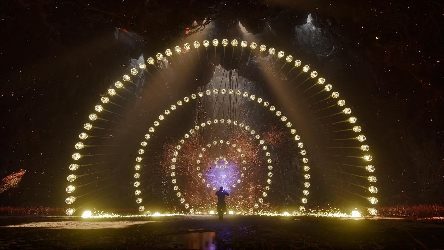 Large illuminated archway with concentric circles and a person standing underneath at night.